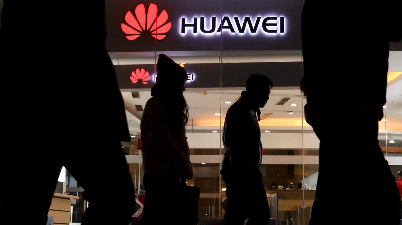 Fußgänger laufen an einem Huawei-Laden in Peking vorbei: Huawei zählt zu den führenden Netzwerkausrüstern weltweit.