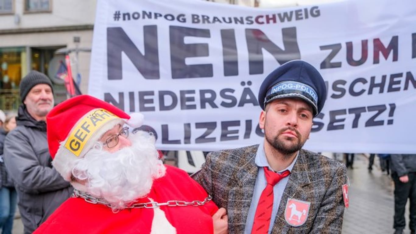 Als Weihnachtsmann und Polizist verkleidet protestieren Teilnehmer des Demonstrationszug gegen das geplante niedersächsische Polizeigesetz.