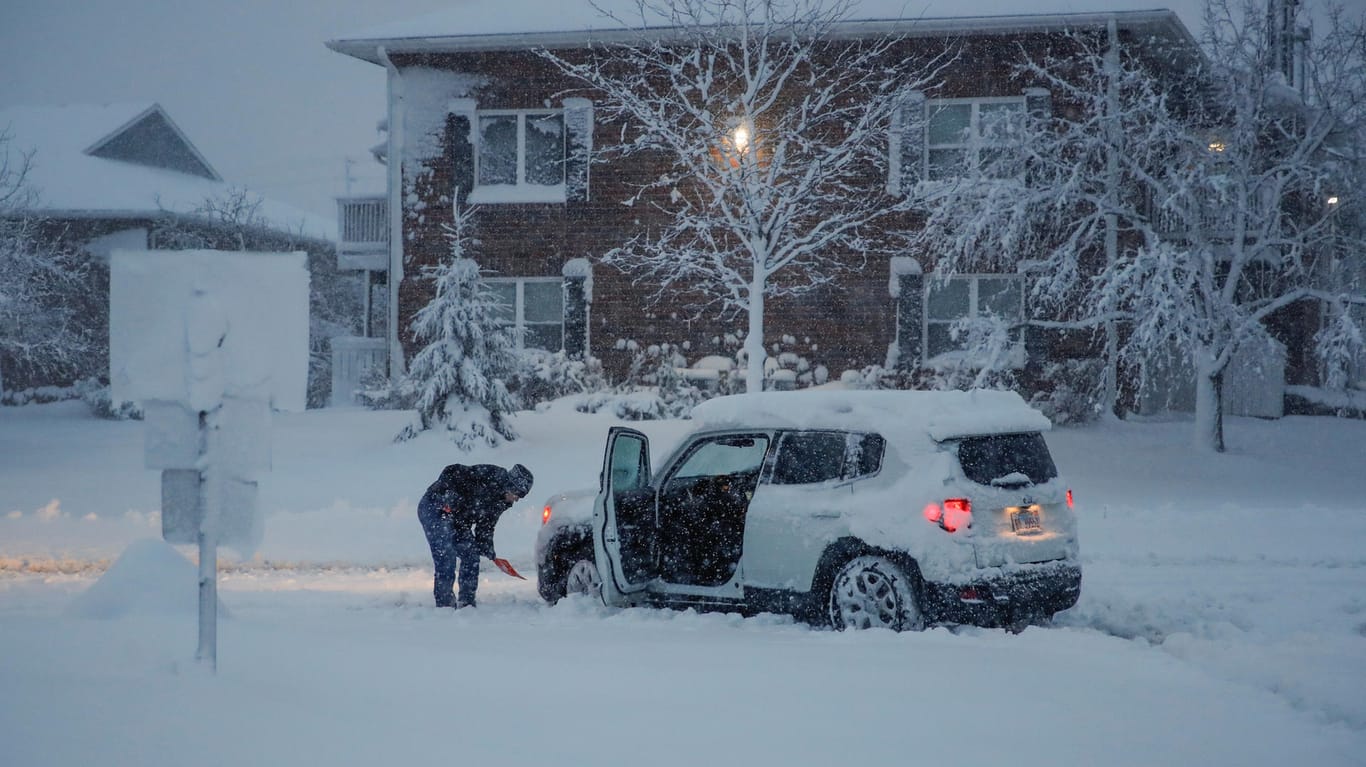 Eine Frau schippt ihr Auto aus dem Schnee frei: Im November traf ein heftiges Unwetter den US-Bundesstaat Illinois, nun wappnen sich die Südost-Staaten für den Sturm. (Archivbild)