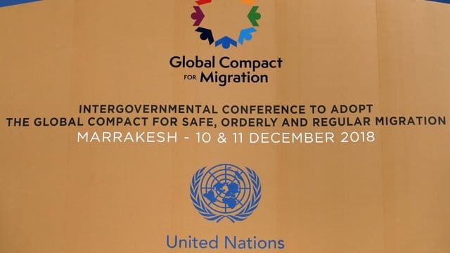 Die Logos der Vereinten Nationen und des Migrationspakts an einem Gebäude in Marrakesch. Die Logos der Vereinten Nationen und des Migrationspakts an einem Gebäude in Marrakesch.