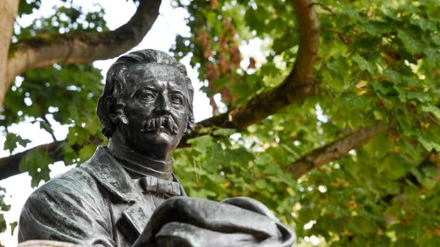 Rastender Wanderer mit Stock und Hut: Theodor Fontane als Denkmal in Neuruppin. Rastender Wanderer mit Stock und Hut: Theodor Fontane als Denkmal in Neuruppin.