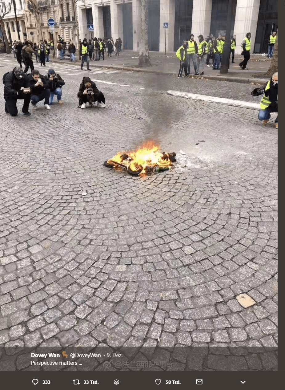 Perspektive 2: Fotografen scharen sich um ein kleines Feuer in Paris. Dieses Bild stimmt von einem anderen Feuer an einem anderern Tag an einem anderen Ort. Beide Fotos haben wenig miteinander zu tun.