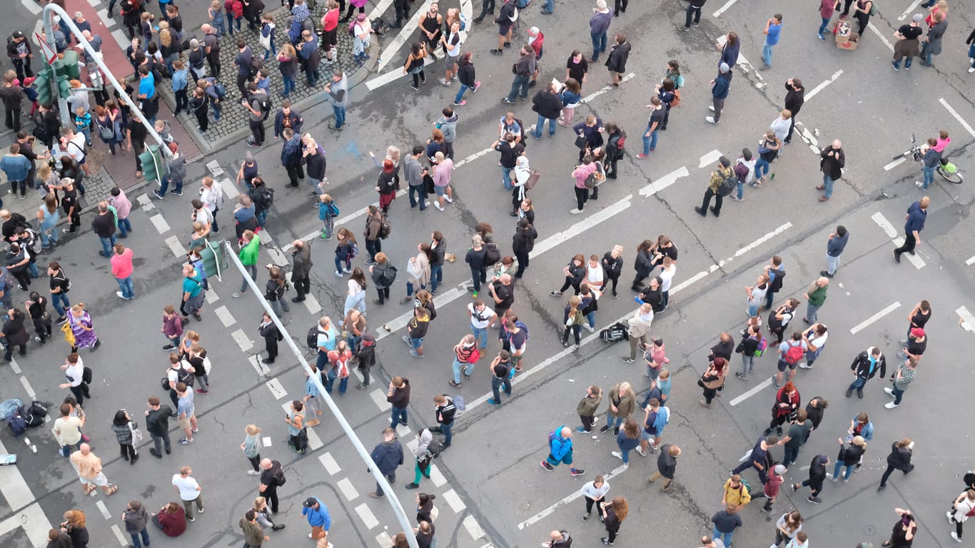 Menschen stehen auf einer Straße: Bei Befragten mit deutschen oder ausländischen Wurzeln fallen die Bewertungen ähnlich aus. (Archivbild)