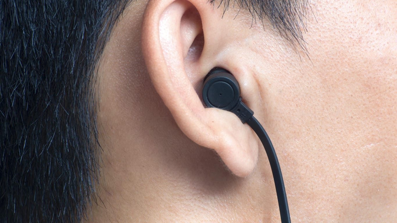 Ein Mann trägt In Ear-Kopfhörer: Können die Geräte tödliche Stromstöße übertragen?