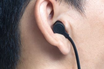 Ein Mann trägt In Ear-Kopfhörer: Können die Geräte tödliche Stromstöße übertragen?