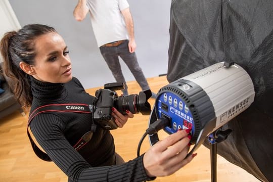 Für ein weicheres Licht setzen Profis im Studio große, schirmartige Softboxen ein, in denen ein Blitz steckt.
