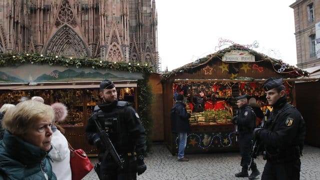 Bewaffnete Polizisten patrouillieren auf dem wiedereröffneten Weihnachtsmarkt in der Straßburger Innenstadt.