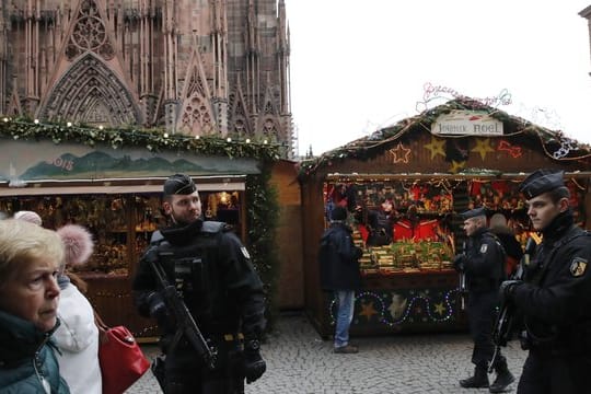 Bewaffnete Polizisten patrouillieren auf dem wiedereröffneten Weihnachtsmarkt in der Straßburger Innenstadt.