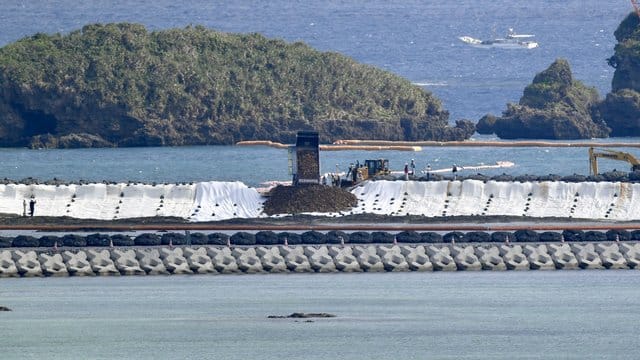 Ein Lkw kippt vor Nago Erdmassen zur Landgewinnung ins Meer.