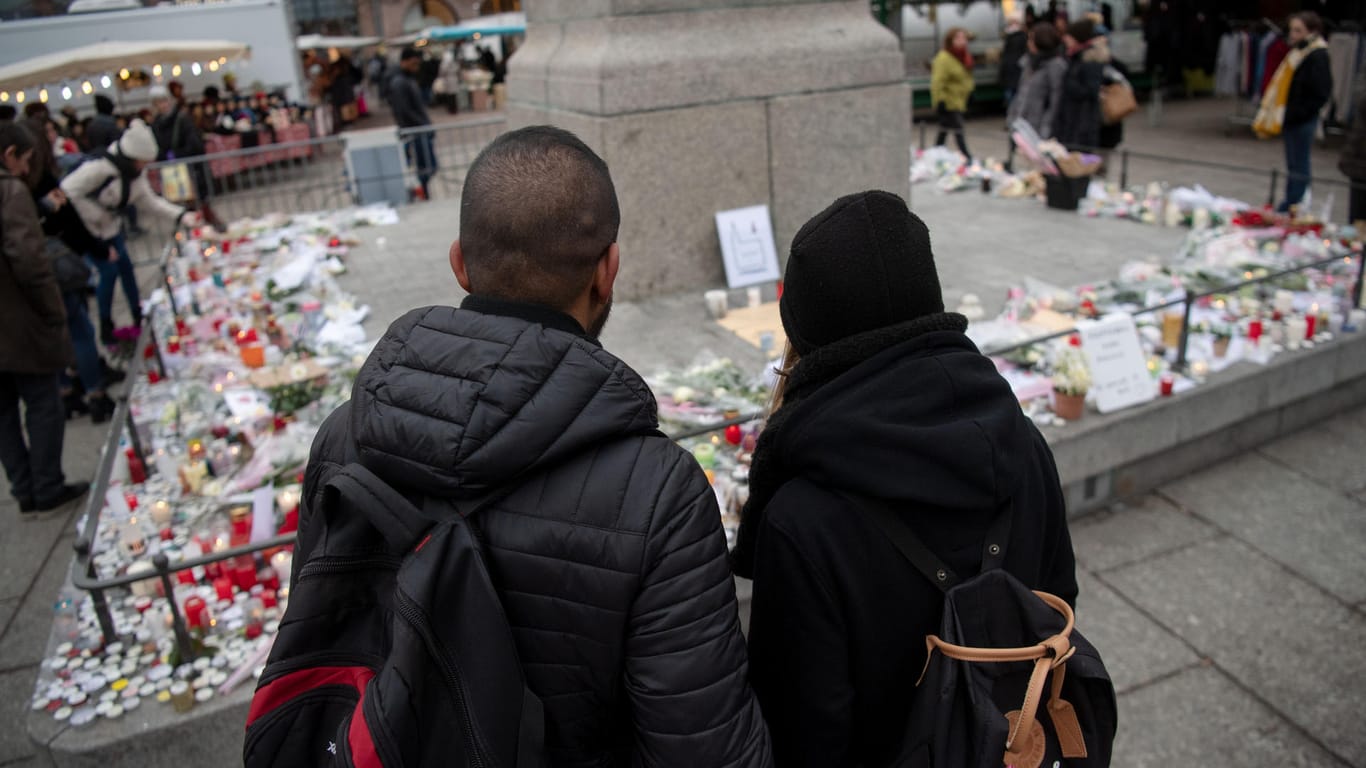 Zwei junge Menschen stehen vor einem Kerzenmeer in Straßburg: Mittlerweile ist ein viertes Opfer an seinen Verletzungen erlegen.