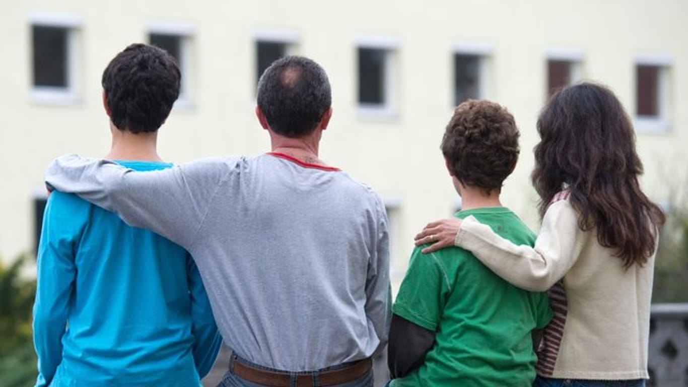 Eine syrische Familie sitzt vor einem Asylwohnheim der Zentralen Ausländerbehörde des Landes Brandenburg in Eisenhüttenstadt.