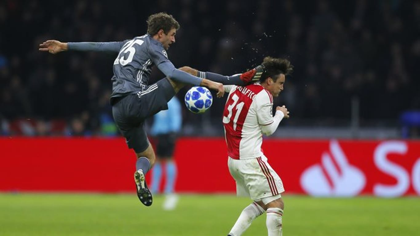 Bayerns Thomas Müller trifft Ajaxs Nicolas Tagliafico (r) mit seinem Fuß am Kopf und flog dafür vom Platz.