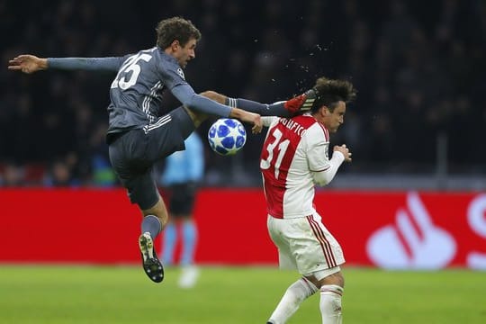 Bayerns Thomas Müller trifft Ajaxs Nicolas Tagliafico (r) mit seinem Fuß am Kopf und flog dafür vom Platz.