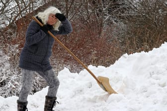 Schippe um Schippe – eine Frau schaufelt Schnee auf einen Hügel: fertig, fertiger, am fertigsten – es gibt einen Trend, Adjektive zu steigern, deren Steigerung oft Unsinn ist.
