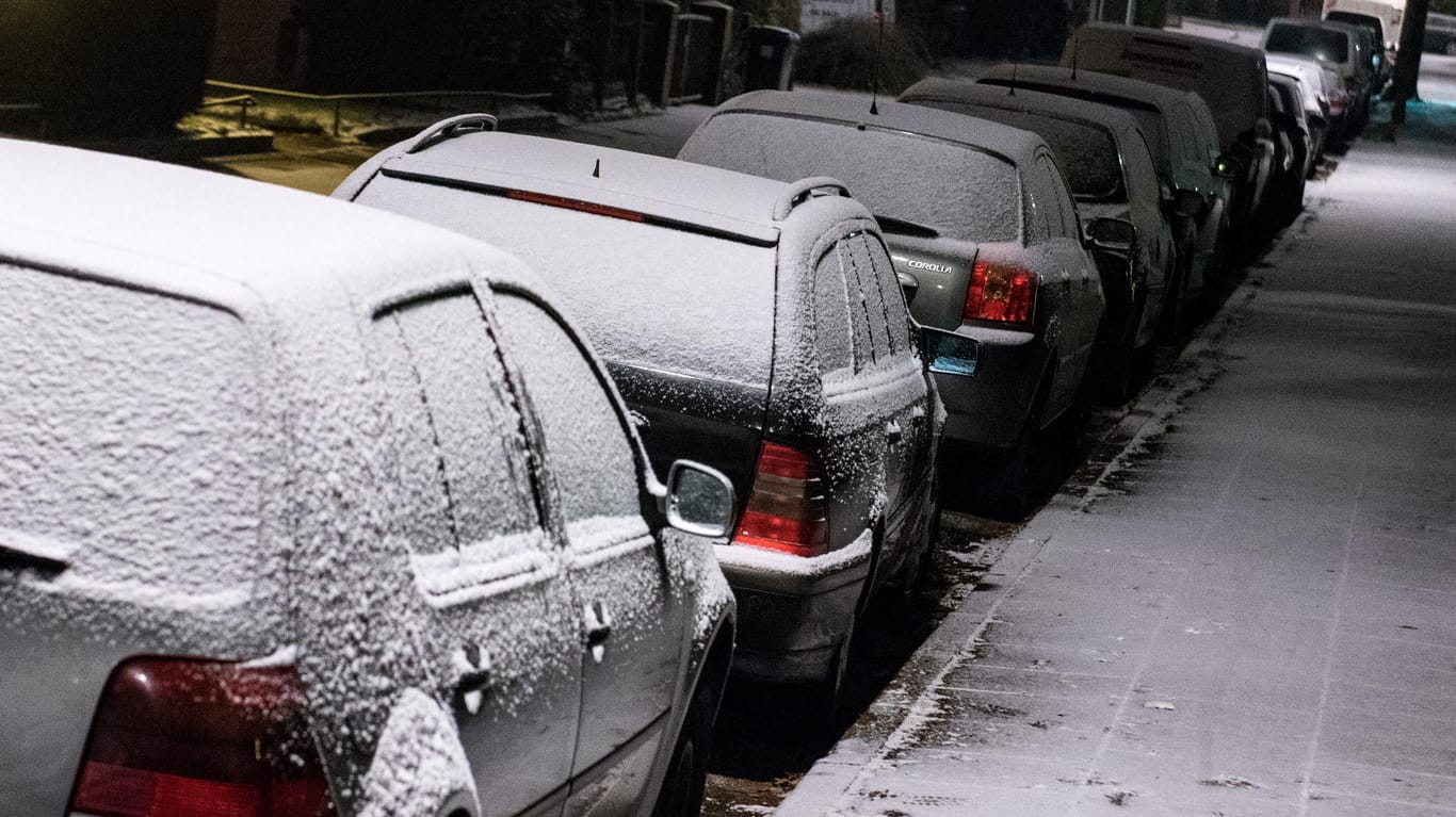 Hamburg: Mit Schnee bedeckte Autos stehen in einer kleinen Wohnstraße. In der Hansestadt hat es am Abend den ersten Schneefall in diesem Winter gegeben.