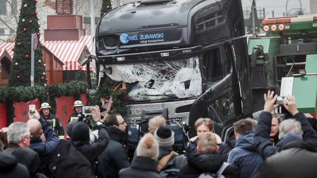 Menschen stehen vor dem LKW, mit dem ein Anschlag auf den Weihnachtsmarkt in Berlin verübt worden war (Archivbild). Menschen stehen vor dem LKW, mit dem ein Anschlag auf den Weihnachtsmarkt in Berlin verübt worden war (Archivbild).
