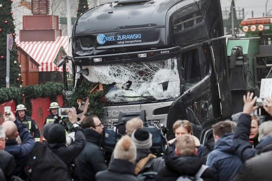 Menschen stehen vor dem LKW, mit dem ein Anschlag auf den Weihnachtsmarkt in Berlin verübt worden war (Archivbild).