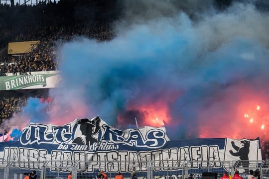 Bei Borussia Dortmund werden Feuerwerkskörper im Berliner Fanblock hinter den Bannern entzündet.