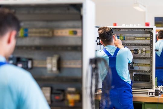 Drei junge Flüchtlinge arbeiten im Ausbildungszentrum der Siemens Professional Education in Leipzig.