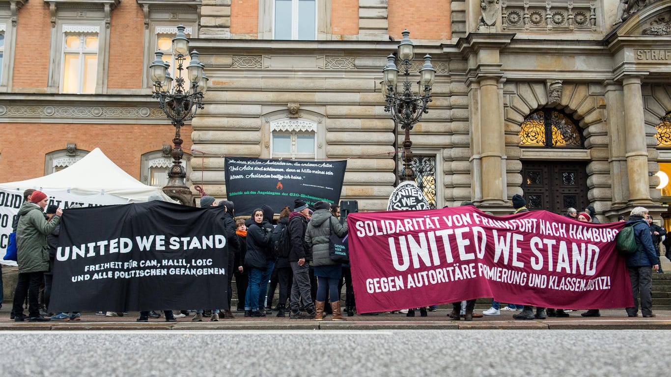 Teilnehmer einer Kundgebung halten vor dem Landgericht Transparente mit der Aufschrift "United we stand": Die Angeklagten beriefen sich auf ihr Demonstrationsrecht.