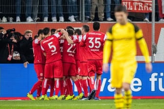 Die Düsseldorfer Spieler (l) freuen sich nach dem Treffer zum 2:0 gegen den BVB.