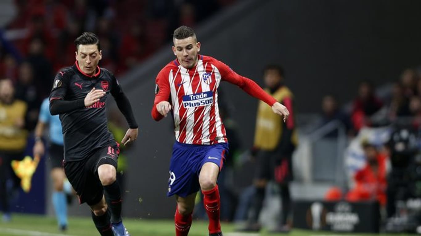 Lucas Hernández (r) von Atlético Madrid in Aktion gegen Mesut Özil.