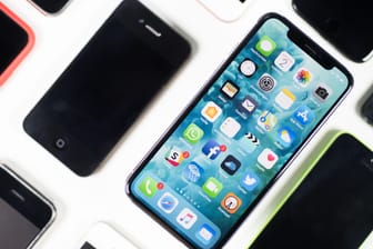 Ein iPhone X liegt neben iPhones anderer Generationen auf einem Tisch. Der Chipkonzern Qualcomm hat in seinem Patentstreit mit Apple ein Verkaufsverbot in Deutschland erstritten, von dem mehrere iPhone-Modelle betroffen sein könnten.