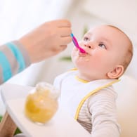Ein Baby wird mit Brei gefüttert: Die erste Beikost besteht meist aus Gemüse, später kommt Fleisch hinzu.