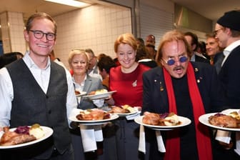 Michael Müller (l-r), Renate Künast, Franziska Giffey und Frank Zander servieren im Hotel Estrel Gänsebraten für die Gäste.