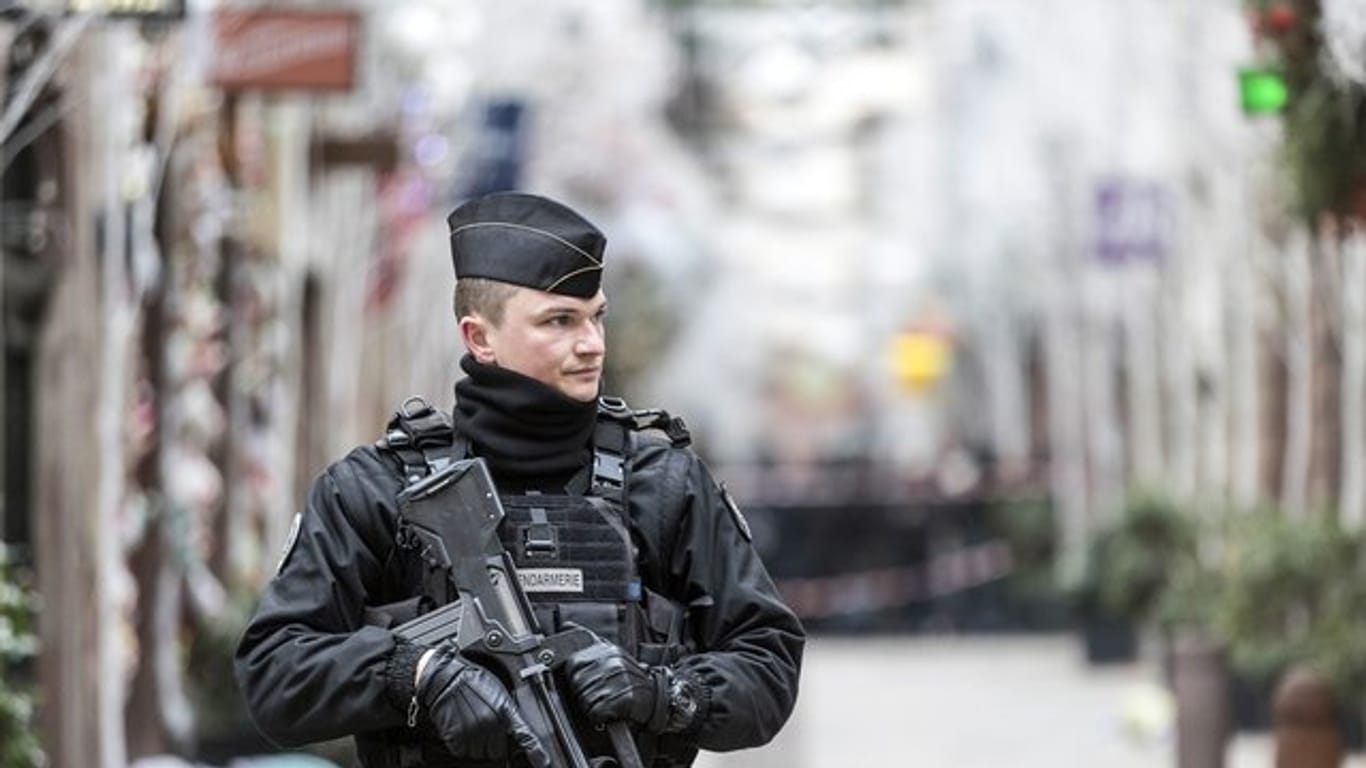 Ein Polizist steht nach einem Angriff in der Gegend des Straßburger Weihnachtsmarkts vor dem Tatort.