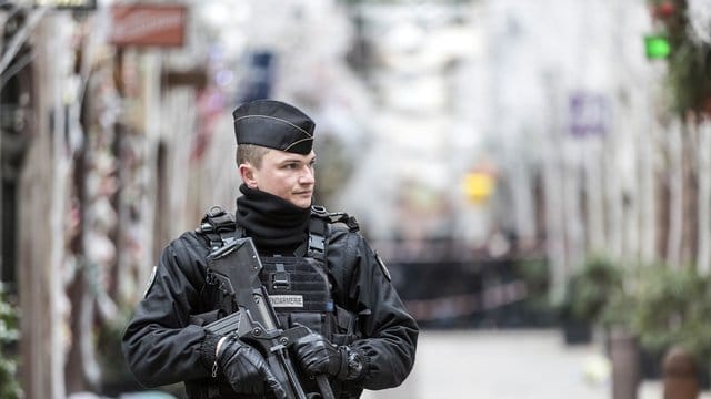 Ein Polizist steht nach einem Angriff in der Gegend des Straßburger Weihnachtsmarkts vor dem Tatort. Ein Polizist steht nach einem Angriff in der Gegend des Straßburger Weihnachtsmarkts vor dem Tatort.