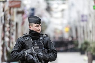 Ein Polizist steht nach einem Angriff in der Gegend des Straßburger Weihnachtsmarkts vor dem Tatort.
