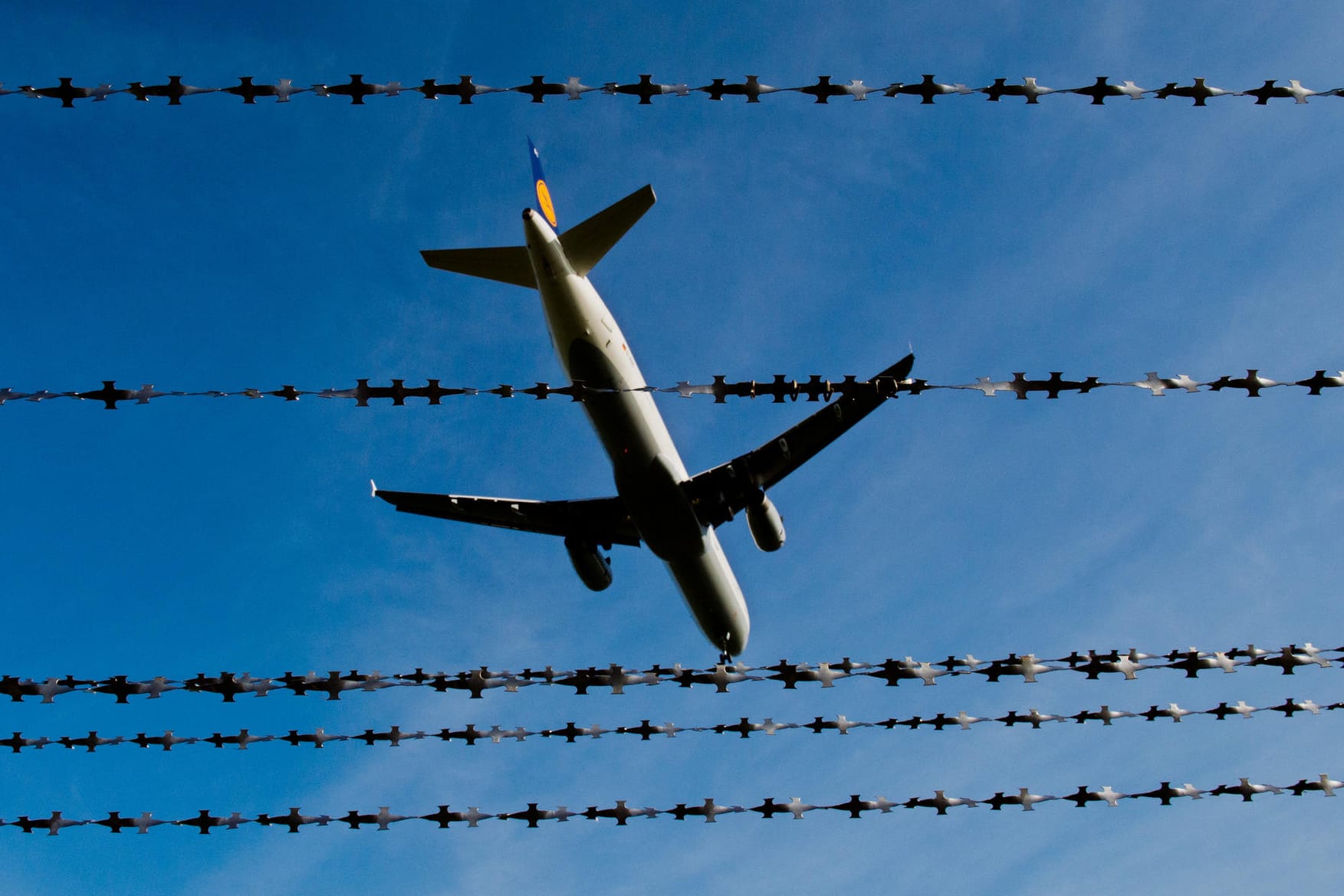 Ein Flugzeug fliegt über Stacheldraht hinweg (Symbolbild): Die Männer wurden ausgeflogen.