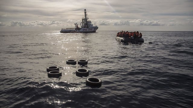 Migranten sitzen in einem Schlauchboot nachdem sie im zentralen Mittelmeer 72 Kilometer von Al Khums (Libyen) gerettet wurden. Migranten sitzen in einem Schlauchboot nachdem sie im zentralen Mittelmeer 72 Kilometer von Al Khums (Libyen) gerettet wurden.