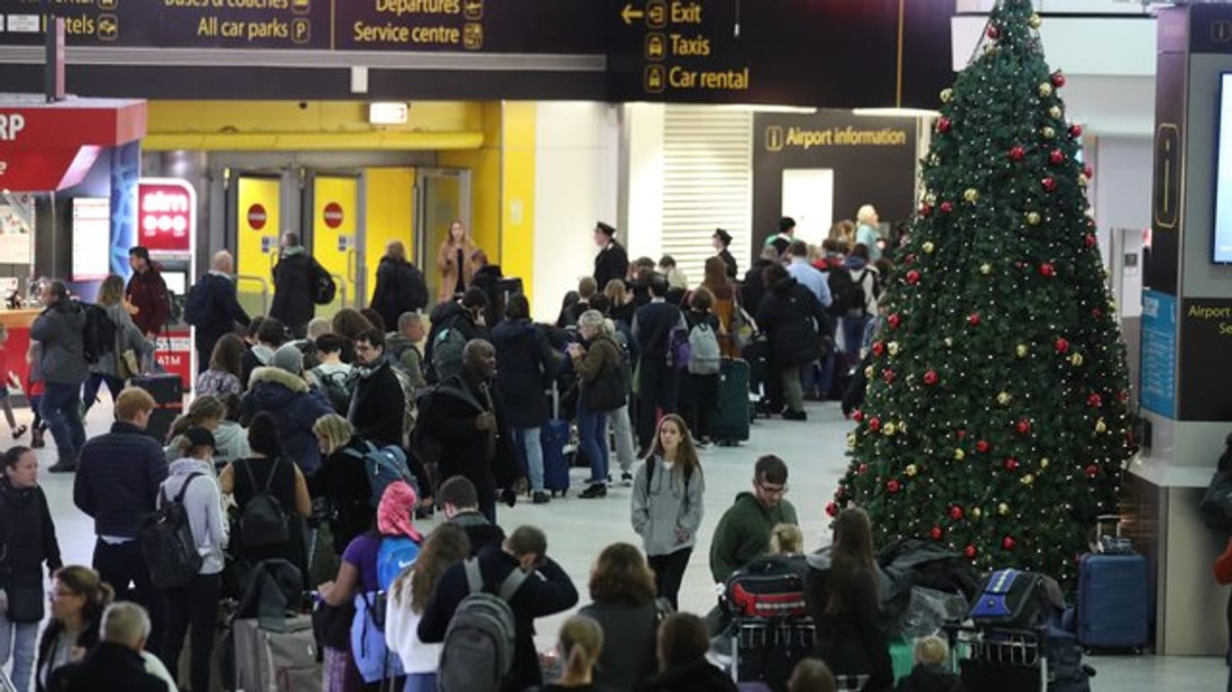 Passagiere am Flughafen Gatwick warten auf ihre Flüge nach den Verspätungen und Annullierungen, die durch Drohnensichtungen verursacht wurden.