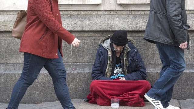 Ein Obdachloser sitzt vor der Victoria Station in London. Ein Obdachloser sitzt vor der Victoria Station in London.