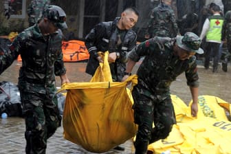 Soldaten tragen einen Leichensack mit der Leiche eines Tsunami-Opfers: Noch immer werden zahlreiche Menschen vermisst.