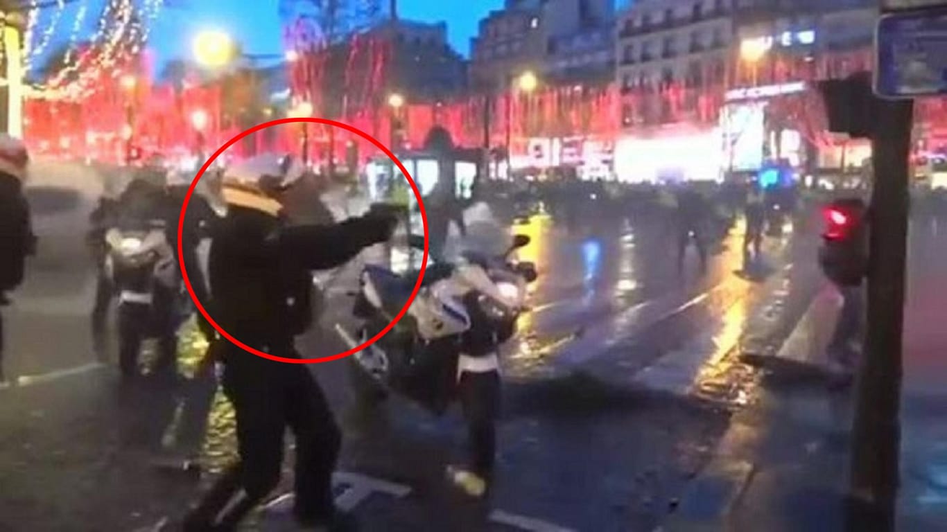 In Bedrängnis: In Paris hat ein Polizist seine Dienstwaffe gegen Demonstranten gerichtet.