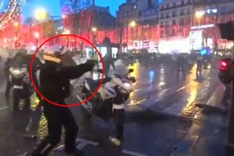 In Bedrängnis: In Paris hat ein Polizist seine Dienstwaffe gegen Demonstranten gerichtet.