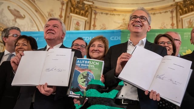 Prima Klima bei Schwarz-Grün: Der hessische Ministerpräsident Volker Bouffier (l, CDU) und Wirtschaftsminister Tarek Al-Wazir (Grüne) mit dem unterzeichneten Koalitionsvertrag. Prima Klima bei Schwarz-Grün: Der hessische Ministerpräsident Volker Bouffier (l, CDU) und Wirtschaftsminister Tarek Al-Wazir (Grüne) mit dem unterzeichneten Koalitionsvertrag.