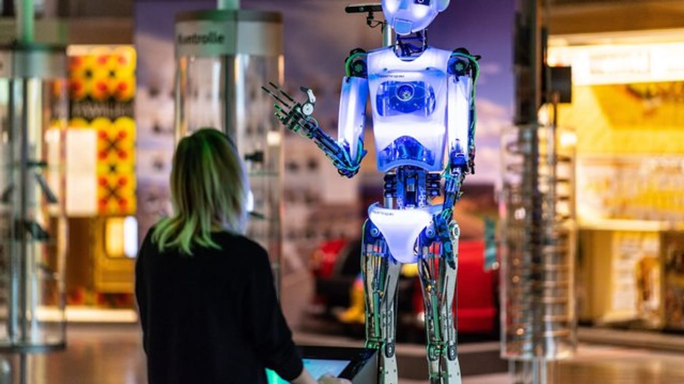 Eine Frau steht in der Ausstellung: "Künstliche Intelligenz und Robotik" im Heinz Nixdorf Museumsforum vor dem Roboter "robothespian".