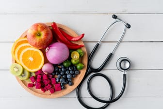 Obst, Gemüse und ein Stethoskop: Eine gesunde Ernährung gilt als wichtige Säule, um Herzkrankheiten vorzubeugen.