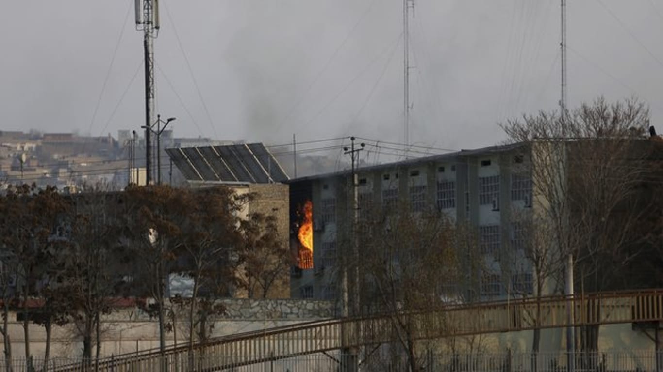 Aus einem Regierungsgebäude steigen nach einer Explosion Flammen auf.