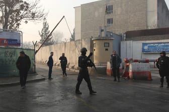 Afghanistan, Kabul: Afghanische Sicherheitskräfte versammeln sich einen Tag später am Ort eines Selbstmordanschlags und bewaffneten Überfalls, bei dem Dutzende von Menschen ums Leben gekommen sind.