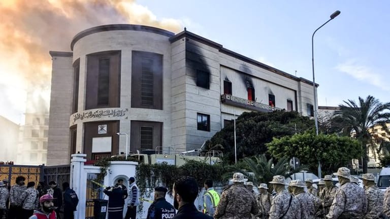 Sanitäter und Sicherheitsleute vor dem Hauptquartier des Außenministeriums, über dem dichter Rauch zu sehen ist.