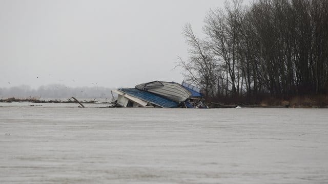 Ein Ponton mit einem ganzen Flussrestaurant löst sich vom Donauufer und treibt flussabwärts. Ein Ponton mit einem ganzen Flussrestaurant löst sich vom Donauufer und treibt flussabwärts.