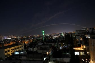 Spuren von Luftabwehrraketen sind am Himmel über Damaskus zu sehen.