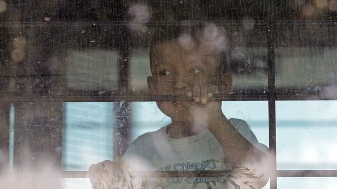 Ein Einwandererkind sieht aus der vergitterten scheibe eines Busses der US-Border Border Patrol.