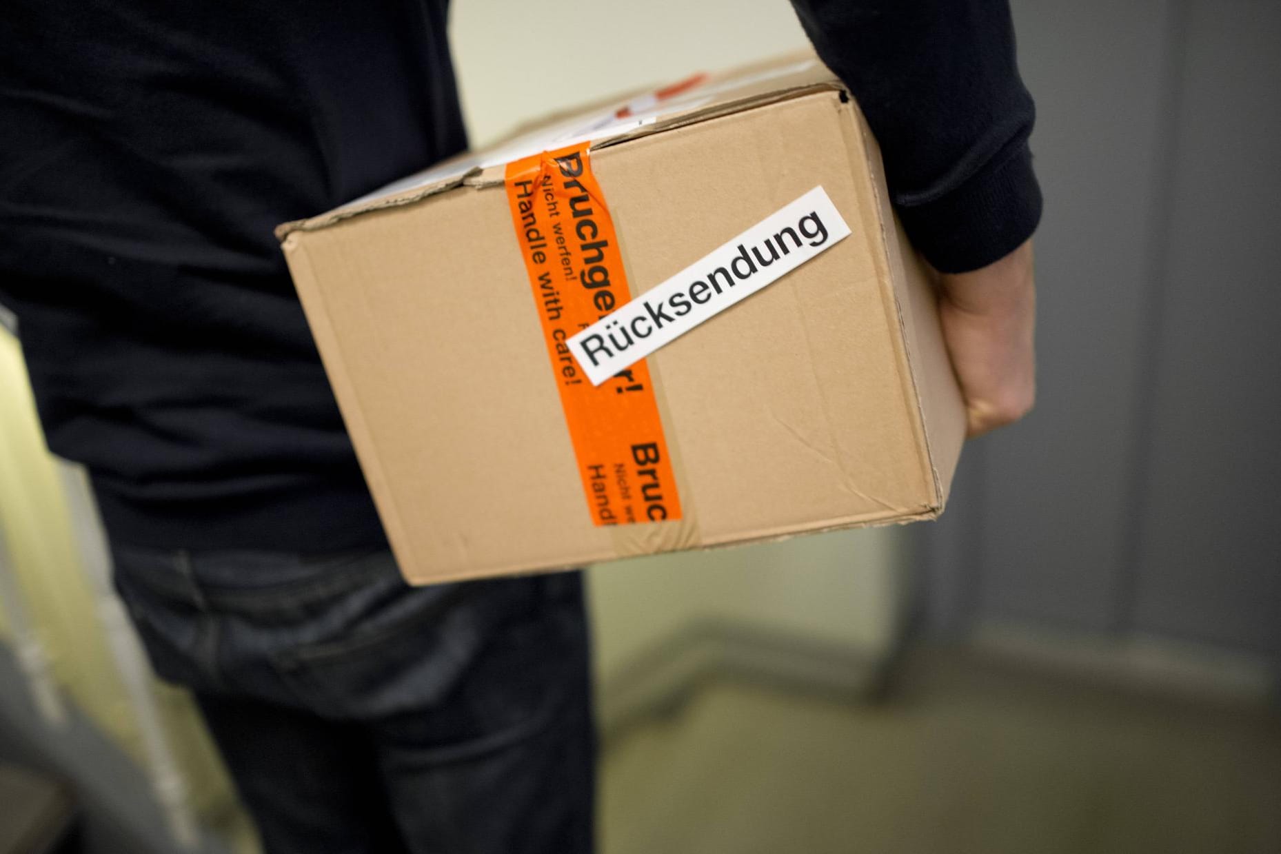 Paketträger mit einem Retoure-Paket. Alles ordnungsgemäß verpackt? Ein Zeuge oder eine Zeugin kann bei Retoure-Problemen mit einem Versandhändler wichtig werden.