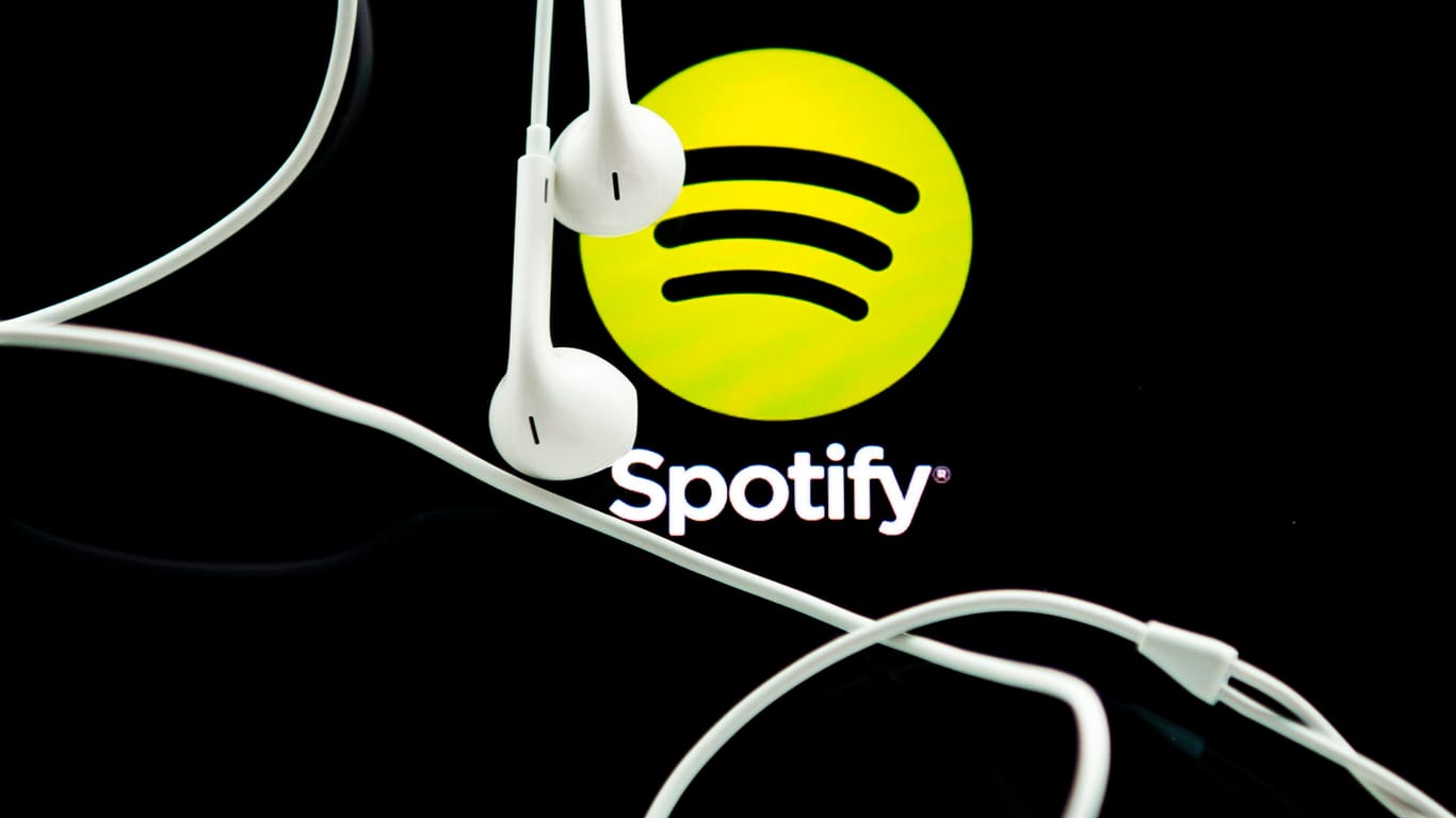Kopfhörer baumeln vor dem Spotify-Logo: Der Streamingdienst feierte 2018 sein Börsendebut.